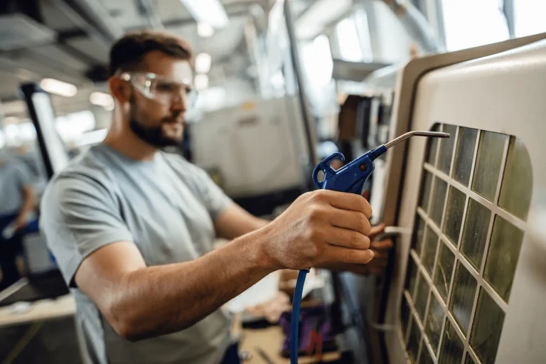 Technician in safety glasses servicing a refrigeration unit