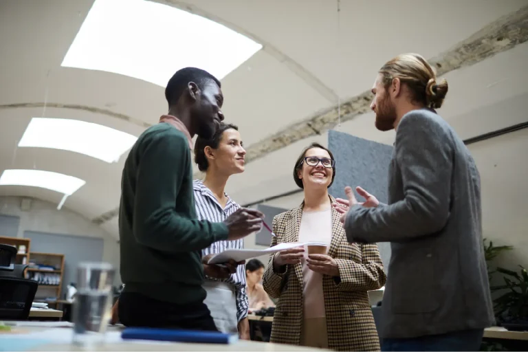 Four colleagues talking together in an office